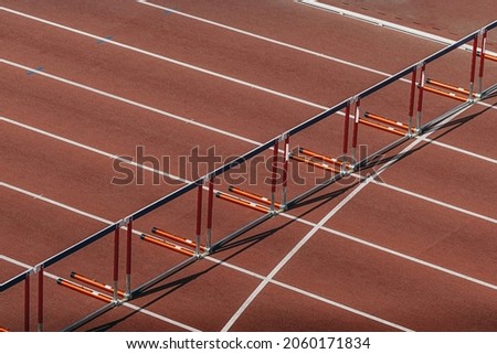 hurdles for running 110 meters on red track of stadium