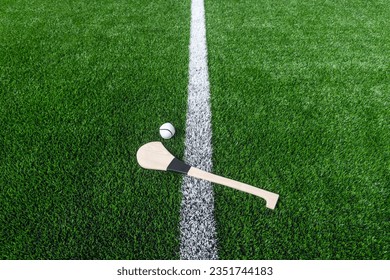 Hurling bat and sloitar on green grass. Horizontal sport theme poster, greeting cards, headers, website and app - Powered by Shutterstock