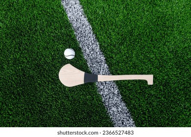 Hurling bat and sloitar on green grass. Horizontal sport theme poster, greeting cards, headers, website and app - Powered by Shutterstock