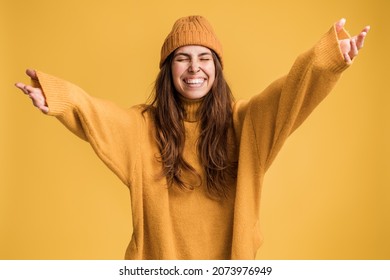Hurray. Portrait of delighted girl yelling for happiness, enjoying life, rejoicing success with arms raised, celebrating triumph, stretching to somebody. Studio shot isolated on yellow background  - Shutterstock ID 2073976949
