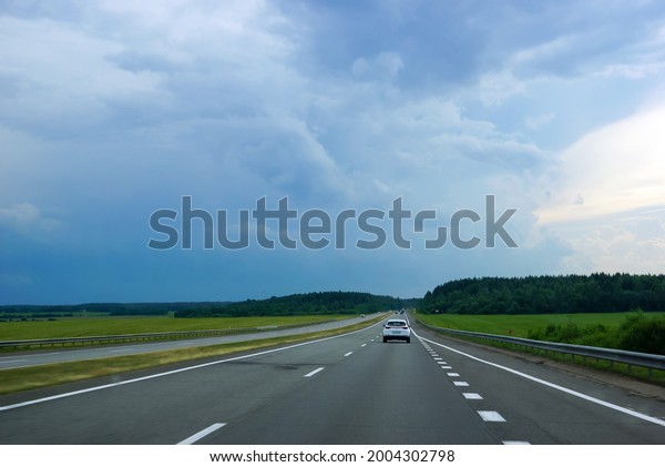 a\
hurricane is coming, the sky is darkening with storm clouds, a\
freeway with cars                              \
