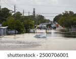 Hurricane Debby flooded city street with trapped car submerged under water in Florida residential area. Consequences of natural disaster