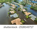 Hurricane Debby flooded street in Sarasota, Florida. Victims boating on rainfall flood waters between rural homes in residential area