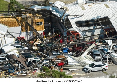 Hurricane Ian destroyed industrial building with damaged cars under ruins in Florida. Natural disaster and its consequences - Shutterstock ID 2210044167
