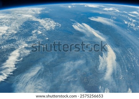 Hurricane warning. An aerial view of rolling hills with fluffy white clouds in a bright blue sky. Sky view from an airplane. Landscape from the air. Elements of this image furnished by NASA