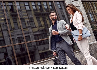 Hurry For Meeting. Two Young Business People Walking Outside On The City Street Drinking Hot Coffee Talking Smiling Joyful Close-up