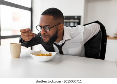 Hurry To Work. Portrait Of Black Business Man Having Breakfast In Kitchen At Home, African American Male In Glasses Wearing Suit While Eating Food, Sitting At Dining Table, Rushing To Office