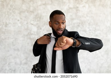 Hurry Up To Work. Portrait of shocked worried black business man with open mouth looking at wrist watch, African American male wearing suit scared of being late to meeting, rushing to office workplace - Shutterstock ID 2052071690
