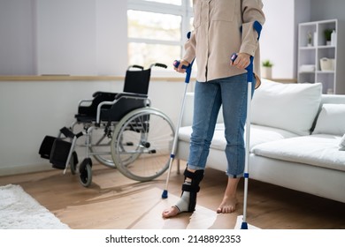 Hurt Leg Using Crutches Near Wheelchair At Home