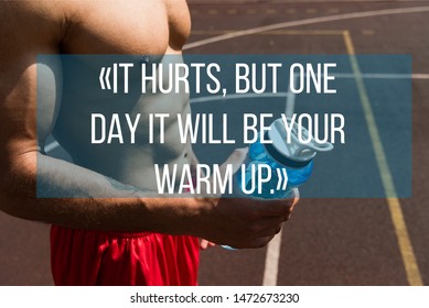 It Hurts, But One Day It Will Be Your Warm Up Lettering On Partial View Of Shirtless Muscular Sportsman Holding Sport Bottle