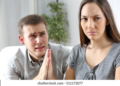 Husband Asking For Forgiveness To His Ex Wife After Conflict Sitting In A Couch In A House