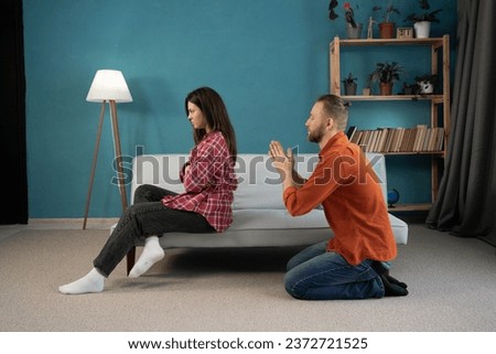 Husband asking forgiveness, making peace with sad wife after quarrel or cheating. Family crisis, relationship problem, break up and divorce. Copy space