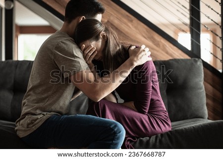 Husband comforting grieving sad wife. Helping a friend giving a shoulder to cry on, family problems, people giving mental support. 