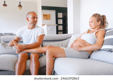 Husband Doing Foot Massage To His Wife On The Coach At Home. Relax Treatment For Your Partner. Couple Reletionship. - Powered by Shutterstock