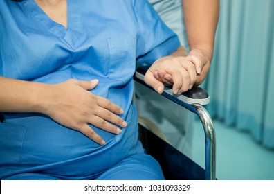 Husband encouraged his wife before entering the labor room,Happy pregnant woman in wheelchair talking with partner and pushing wheelchair to labor room ,Husband support his wife by hand in hand, - Powered by Shutterstock