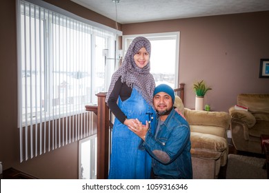 A Husband With His Pregnant Wife Inside Their Home During Winter In Canada