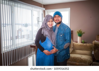 A Husband With His Pregnant Wife Inside Their Home During Winter In Canada