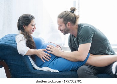 The Husband Sat On The Sofa, Listened To His Pregnant Wife, And Was Happily Talking With The New Family In Home.Pregnancy And People Concept.