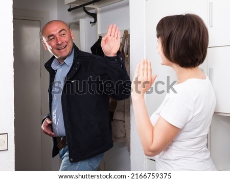 Husband says goodbye to her wife in the hallway of the apartment. High quality photo