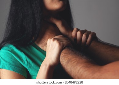 husband strangles wife on gray background
