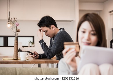 Husband suffering from the wasteful habits of his wife's net shopping - Shutterstock ID 1202131516