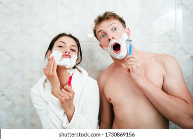 Husband and wife are in the bathroom with a razor in their hands, applied white shaving foam and want to shave their face. Funny young couple in love in the bathroom. Depilation, remove excess bristle - Powered by Shutterstock