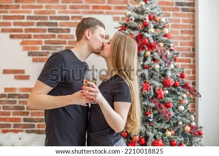 Husband and wife celebrate New Year together. Photo of two people holding glasses of shampagne on Christmas