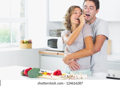 Husband And Wife Having Fun Preparing Vegetables In The Kitchen