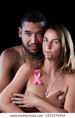 husband and wife hugging for breast cancer on a black background.