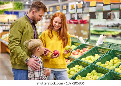 husband and wife with a kid buy fruits, apples. family of three choosing fresh apple in fruits department of supermarket or market - Powered by Shutterstock