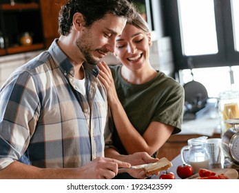 Husband And Wife In Kitchen. Young Couple Preparing Delicious Food At Home.