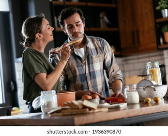 Husband and wife in kitchen. Young couple preparing delicious food at home. - Powered by Shutterstock