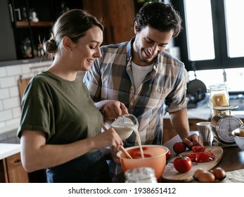 Husband and wife in kitchen. Young couple preparing delicious food at home.