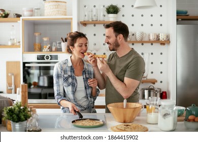 Husband and wife making pancakes at home. Loving couple having fun while cooking	 - Powered by Shutterstock