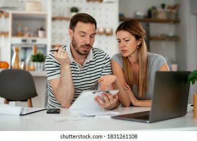 Husband and wife preparing bills to pay. Young couple having financial problems. - Shutterstock ID 1831261108