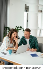 Husband And Wife Preparing Bills To Pay. Young Couple Using Laptop.