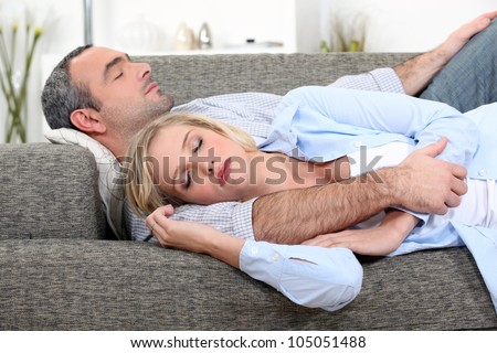 Husband and wife sleeping on their couch