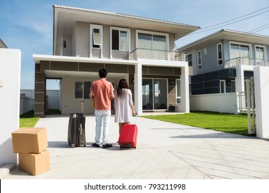 Husband And Wife Standing In Front Of New Buying Home With Luggage And  Boxes. Happy Asian Married Male And Female Couple Move To Modern House. Family Lifestyle New Life. They Bought First Home 