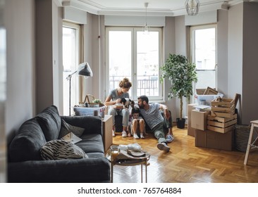 Husband And Wife And Their Child Moving In New Home.