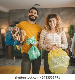 husband and wife woman and man family recycle at home sorting waste plastic paper and glass to green, yellow and blue bags sustainable living concept - Powered by Shutterstock