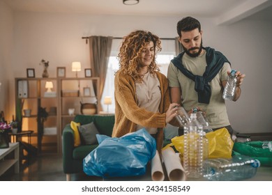 husband and wife woman and man family recycle at home sorting waste plastic paper and glass to green, yellow and blue bags sustainable living concept - Powered by Shutterstock