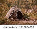 Hut of ancient people. Prehistoric dwelling place, primitive architecture. Wigwam made of animal skins surrounded with mammoth tusks. The cabin of an ancient man. Leathers shelter of primitive man