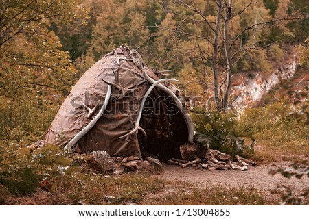 Hut of ancient people. Prehistoric dwelling place, primitive architecture. Wigwam made of animal skins surrounded with mammoth tusks. The cabin of an ancient man. Leathers shelter of primitive man