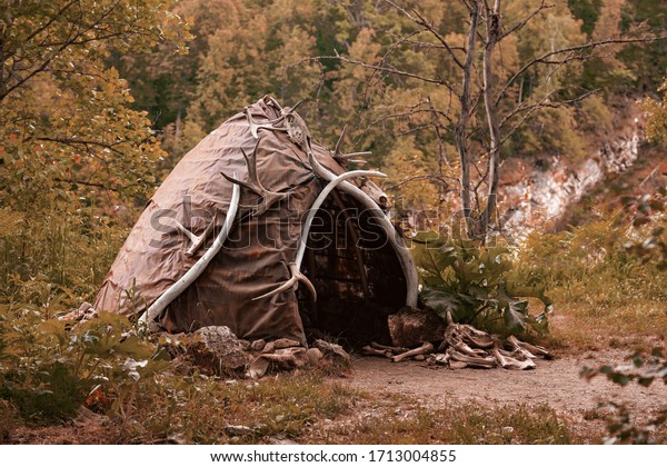 Hut of ancient people. Prehistoric dwelling place,\
primitive architecture. Wigwam made of animal skins surrounded with\
mammoth tusks. The cabin of an ancient man. Leathers shelter of\
primitive man