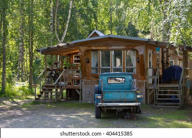 A hut in the  Southern States with a pickup in front
