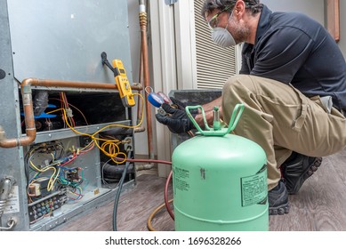 HVAC Contractor Wearing PPE, Servicing A Heat Pump