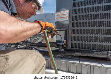 Hvac Contractor, Wearing Safety Gera, Sweating The Copper Piping On A New Condensing Unit Install