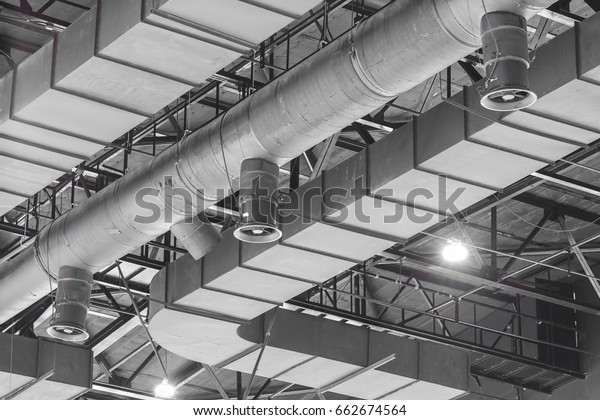 HVAC Duct\
Cleaning, Ventilation pipes in silver insulation material hanging\
from the ceiling inside new\
building.