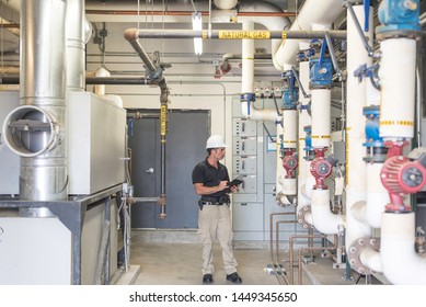 HVAC Engineer Doing An Inspection Inside Of A Boiler Room. 