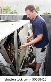 An HVAC Heating Ventilating Air Conditioning Technician Working On A Large Commercial Unit.